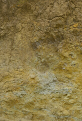 Texture of a wall of solid yellow and brown sand in a sandy quarry