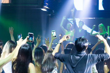 Audience Captures the show with smartphone. music concert live on stage. diverse young people...