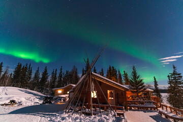 Aurora Borealis, Northern Lights, over aboriginal wooden cabin at Yellowknife, Northwest...
