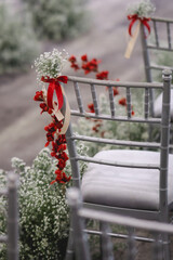 white chair with red and white flowers decoration in wedding ceremony