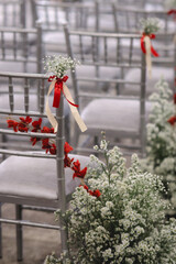 white chair with red and white flowers decoration in wedding ceremony