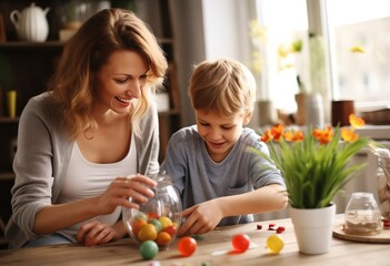 Fototapeta na wymiar happy beautiful mother and little boy decorating easter egg 