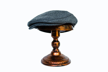 Detail of a scaly hat or flat cap or made of tweed herringbone mounted on a bronze mannequin head...