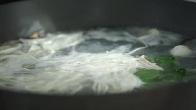 Boiling mustard greens and enoki mushrooms