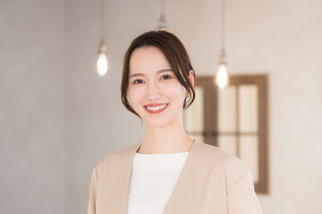 カメラ目線の若いオフィスカジュアルの女性　クローズアップ