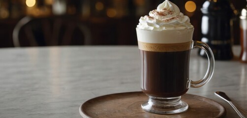  The image features a table with a plate holding a cup of coffee and whipped cream on top. The cup appears to be filled with some type of.
