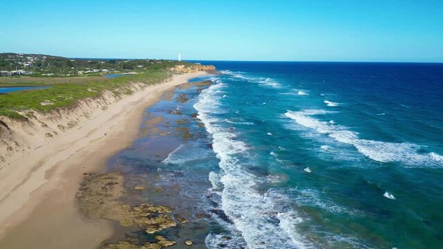 Aerial view, drone video of Fairhaven beach, Australia, Great Ocean Road. Beautiful coastline view of australian beach with lighthouse
