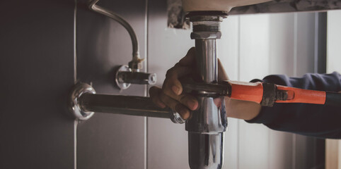 plumber at work in a bathroom, plumbing repair service , fix water plumbing leaks, replace the kitchen sink drain
