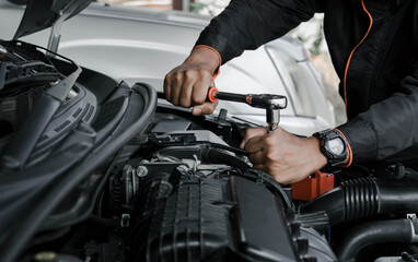 Mechanic fixing a car at home. Repair and service.