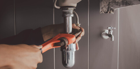 plumber at work in a bathroom, plumbing repair service , fix water plumbing leaks, replace the...
