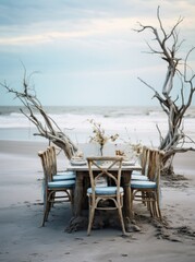 Coastal dining table elegantly set for an event, framed by twisted driftwood and ocean views