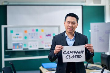 A businessman show paper with owrding company closed for go out of business concept.