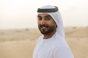 Business men wearing traditional uae white kandura spending time in the desert of Dubai.