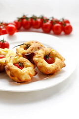 cakes with cherry tomatoes on white plate