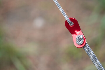 Close up photo of an aluminum tools with rope for tightening and strengthening tents from wind and...