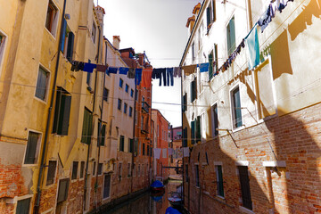Moored covered boats at canal at the old town of Italian City of Venice on a sunny summer day. Photo taken August 7th, 2023, Venice, Italy.