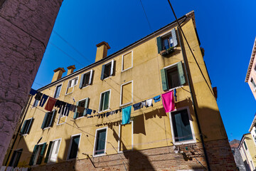 House facade with drying clothes on clothesline at Italian City of Venice on a sunny summer day. Photo taken August 6th, 2023, Venice, Italy.