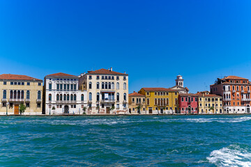 Fototapeta na wymiar Old town of Italian City of Venice with colorful facades of historic houses seen from Canale san Giorgio on a sunny summer day. Photo taken August 7th, 2023, Venice, Italy.