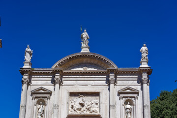 White church of San Rocco with sculptures on rooftop at City of Venice on a sunny summer day. Photo taken August 6th, 2023, Venice, Italy.