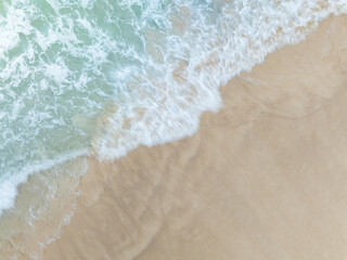 Top view beach with waves crashing on sandy shore,Beautiful waves sea surface in summer seascape background,Amazing beach colorful water background