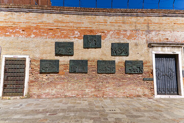 Old town of Venice with barbed wire and brick wall holocaust memorial at Ghetto Novo on a sunny...