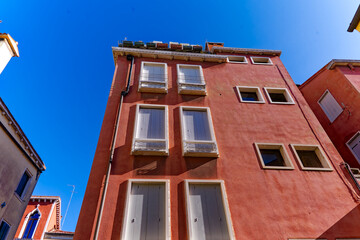 Looking up red facade of historic apartment building at Italian City of Venice on a sunny summer day. Photo taken August 7th, 2023, Venice, Italy.