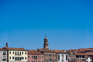 Fototapeta na wymiar Old town of Italian City of Venice with colorful facades of historic houses and church tower seen from Canale san Giorgio on a sunny summer day. Photo taken August 7th, 2023, Venice, Italy.