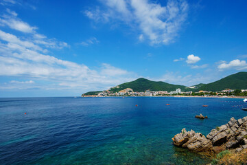 Naklejka premium summer vacation seascape, beautiful seaside resort, beach, city in the distance and hotels on the mountainside, adriatic sea