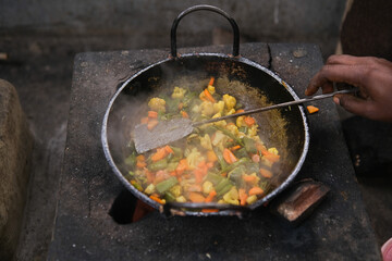 frying pan with vegetables. woman cooking vegetables in a pan