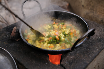 woman frying fresh mixed vegetables in a pan.