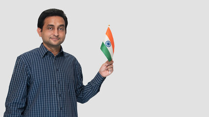 On the ceremony of 26 January in India, a young Indian man waved the national flag in his right hand with a patriotic feeling and an isolated white background.