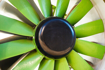 Airplane turbine propeller with green blades close-up.