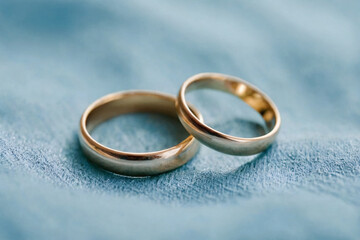 Obraz na płótnie Canvas Two simple wedding rings resting on a precious light blue fabric