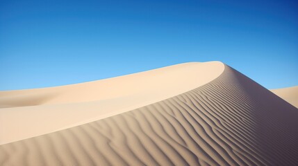 Smooth curves of a vast sandy desert dune under a clear blue sky.
