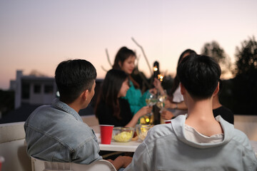 Male and female friends talking and sharing nice moments together at the rooftop party