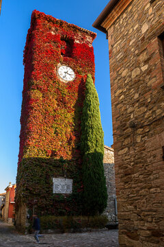 The characteristic bell tower of Frontino, small village in the Pesaro-Urbino province, covered by colored leaves during the autumn