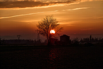 Cascinale al tramonto in un campo
