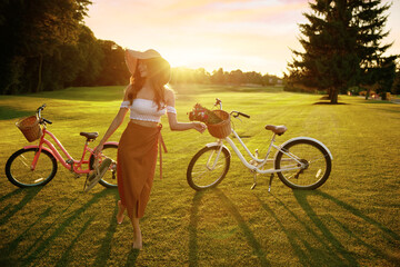Cute barefoot young female bicyclist on park grass lawn - obrazy, fototapety, plakaty