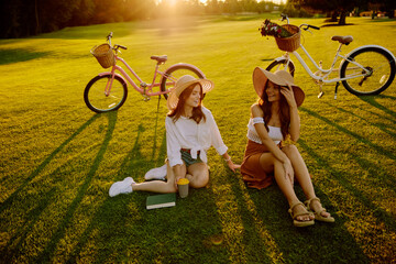 Two young hipster women taking rest coffee break after bike race
