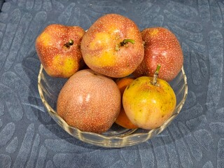 A luscious yellowish-red passion fruit, its vibrant skin blending warm hues, holds a promise of tropical delight. The slightly wrinkled exterior hints at perfect ripeness, while inside, its juicy, aro