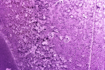 Frost patterns on a window in winter day (pink background)