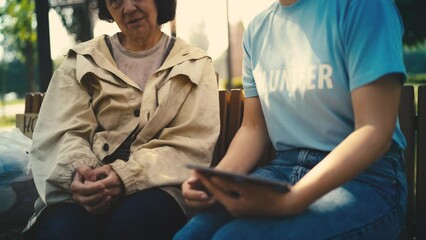 Volunteer communicating with senior homeless woman, charity organization, help