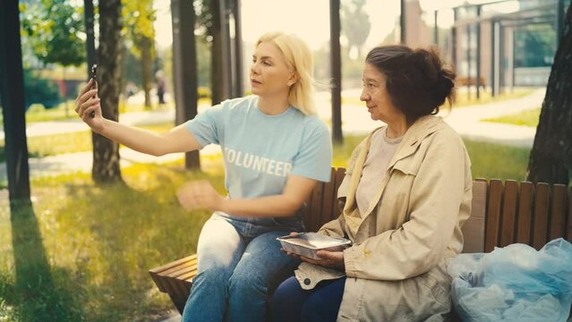 Female volunteer taking a picture with homeless woman to help raise awareness