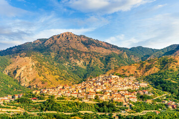 highland landscape of italian town between amazing green mountains with scenic sunset cloudy sky on background