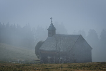 Alte Kapelle auf dem Berg, Nebel Wald und Wiese umgibt die Alpen - Kapelle