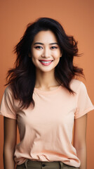 Fototapeta premium Portrait of a beautiful asian woman smiling at camera, over brown background