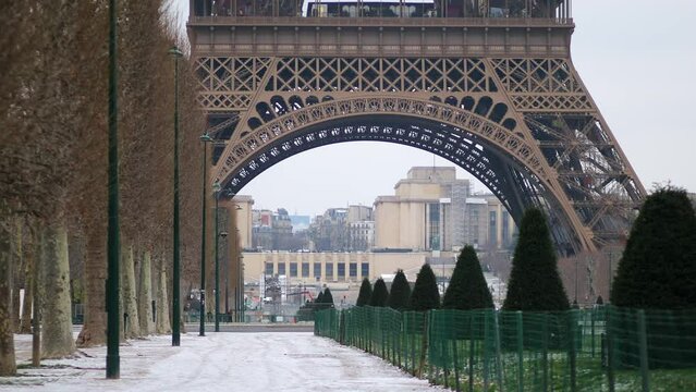 Scenic view to the Eiffel tower on a snowy day. Thin layer of snow on the ground