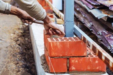 professional construction worker, industrial mason  laying bricks, building house on industrial site