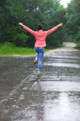 Rain city happy girl jumping in the puddle