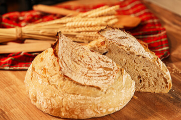 Fresh home made bread on the kitchen wood counter top. Photo a delicious sourdough bread got out of the oven. Bake bread at home.